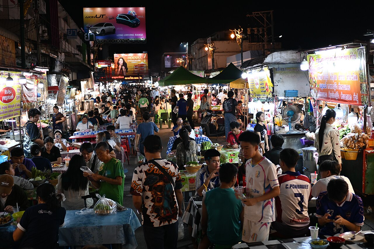 DFC 3506 A lively night market crowded with people eating shopping and strolling beneath b