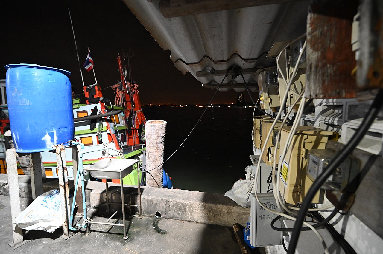 DSC 6587 A dimly lit fishing pier at night with equipment and tangled cables along the she